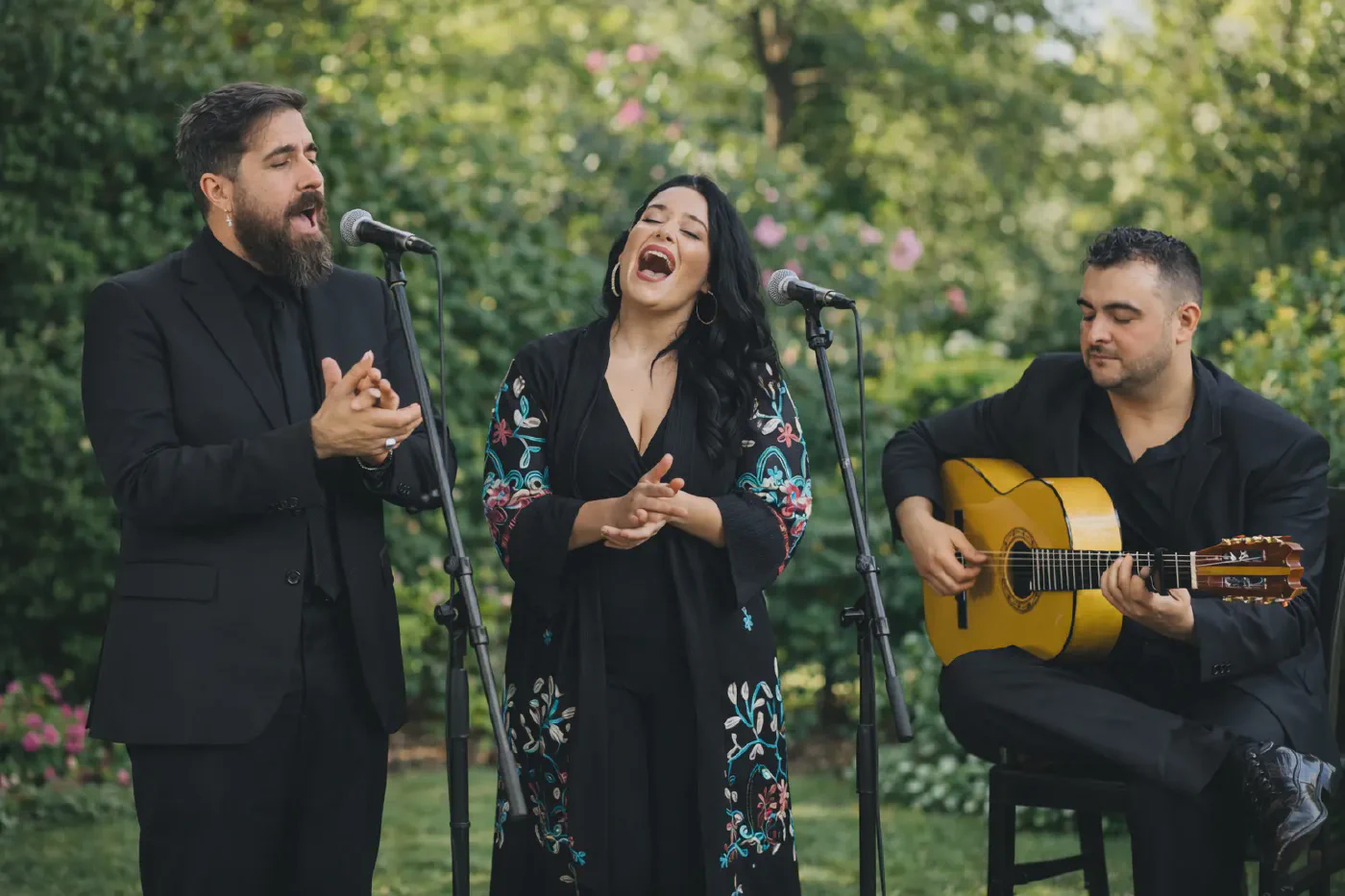 Trío flamenco actuando en directo en un jardín